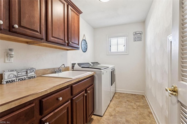 laundry room with sink, washing machine and dryer, and cabinets