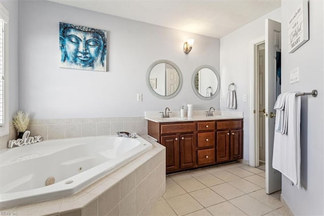 bathroom featuring a healthy amount of sunlight, vanity, tile patterned flooring, and tiled tub