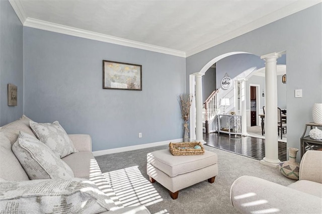 living room with crown molding, dark carpet, and decorative columns