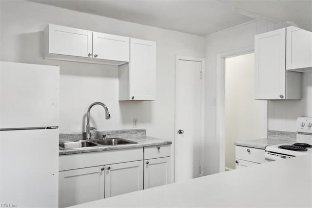 kitchen with sink, white appliances, and white cabinets