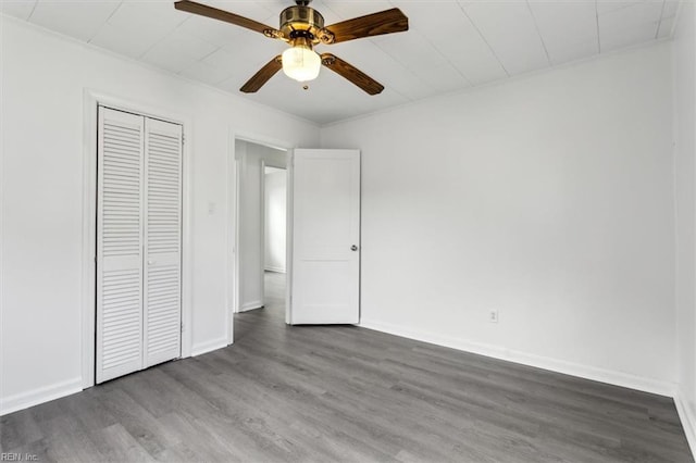 unfurnished bedroom featuring dark hardwood / wood-style floors, ceiling fan, and a closet