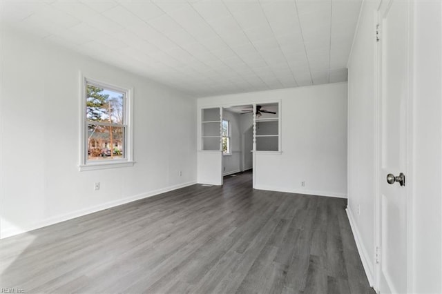 unfurnished room featuring plenty of natural light, dark wood-type flooring, and ceiling fan