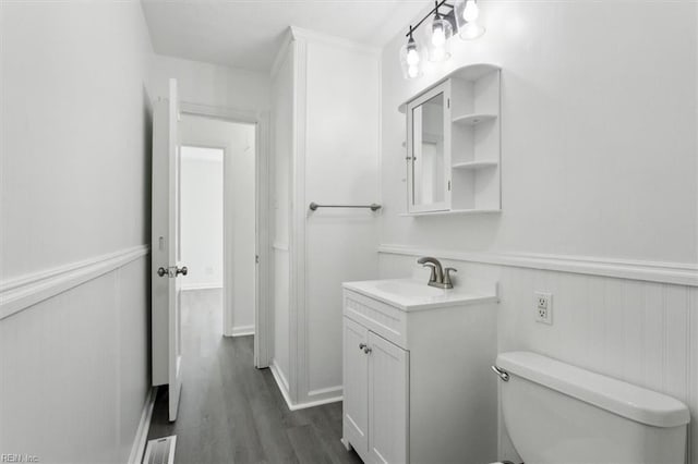 bathroom with vanity, hardwood / wood-style floors, and toilet