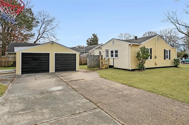 view of side of property with a garage, an outbuilding, and a lawn