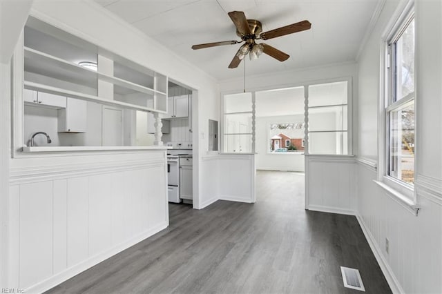 kitchen with electric stove, dark hardwood / wood-style flooring, ornamental molding, and electric panel