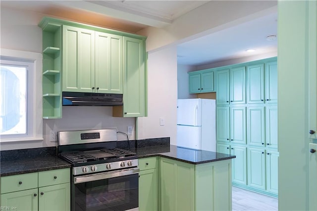 kitchen featuring dark stone countertops, white refrigerator, kitchen peninsula, gas stove, and light hardwood / wood-style flooring