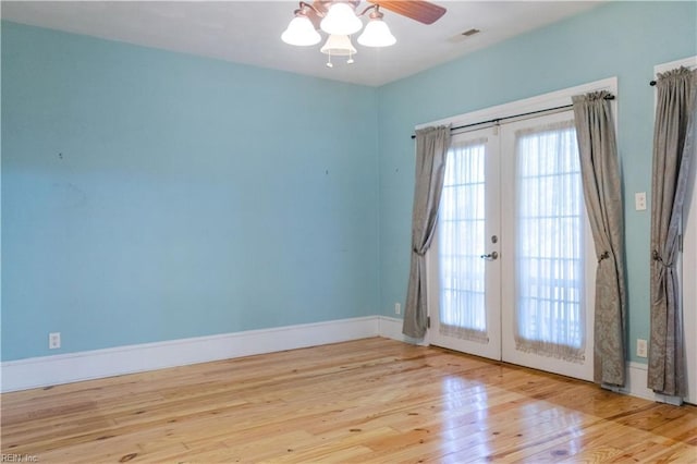 spare room with french doors, ceiling fan, and light wood-type flooring