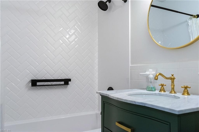 bathroom featuring vanity, backsplash, and tiled shower / bath