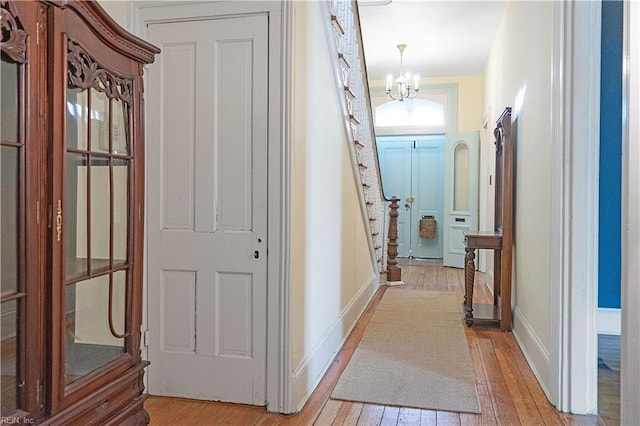 corridor featuring a notable chandelier and light hardwood / wood-style floors