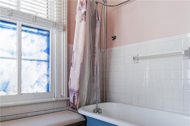 bathroom with tile walls and a tub to relax in