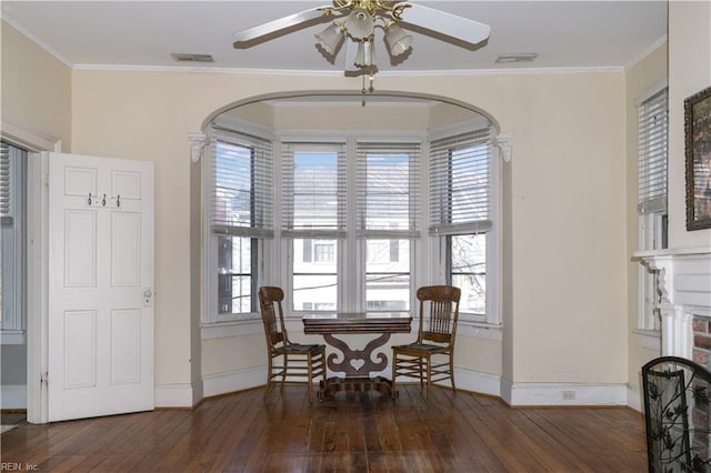 dining space featuring dark hardwood / wood-style flooring, crown molding, and ceiling fan