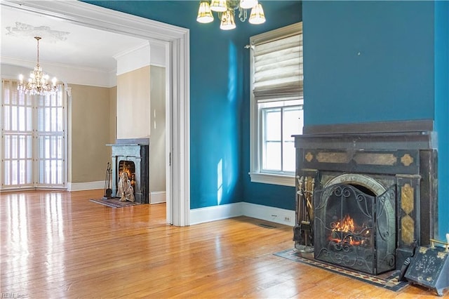 living room with an inviting chandelier, hardwood / wood-style floors, and a healthy amount of sunlight