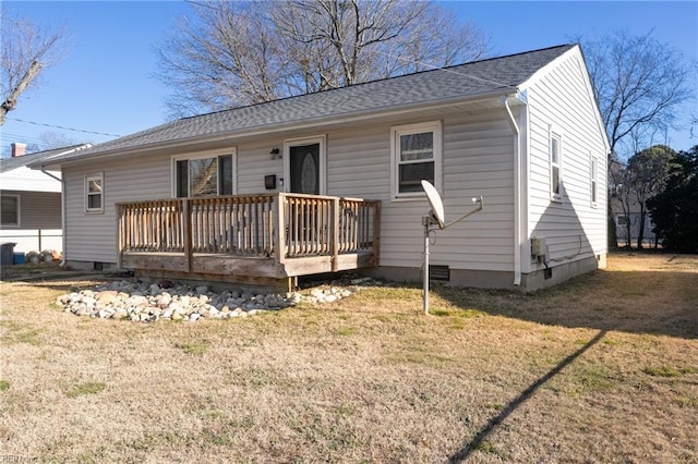 back of house featuring a wooden deck and a lawn