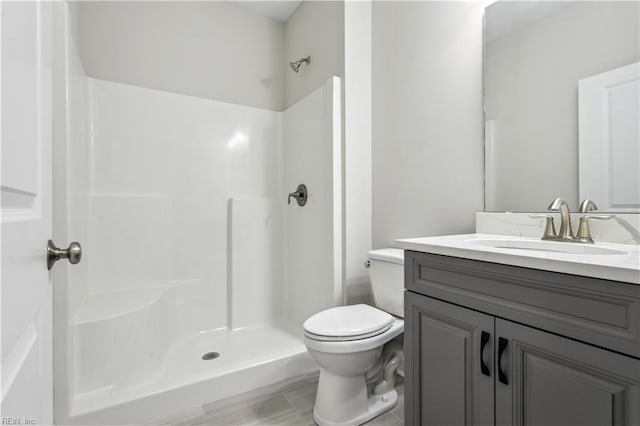 bathroom featuring vanity, toilet, and walk in shower