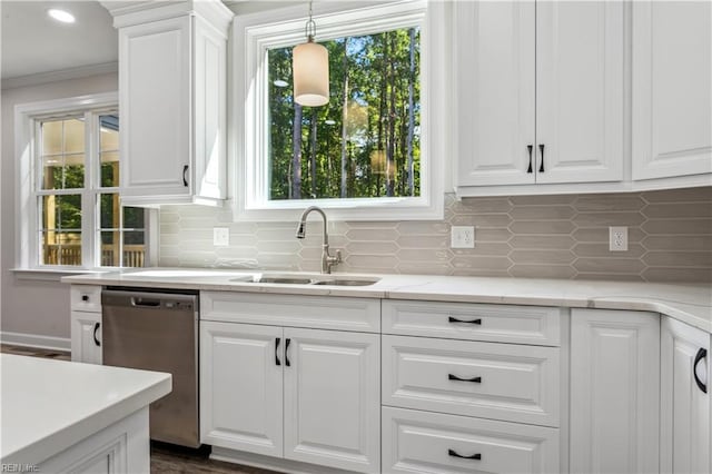 kitchen featuring pendant lighting, white cabinetry, dishwasher, sink, and decorative backsplash