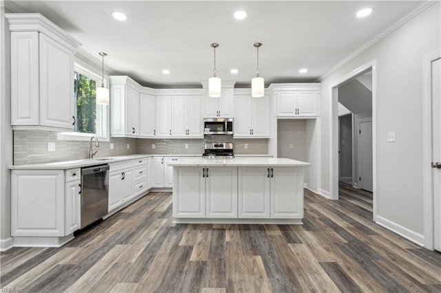 kitchen featuring pendant lighting, white cabinetry, stainless steel appliances, and a center island