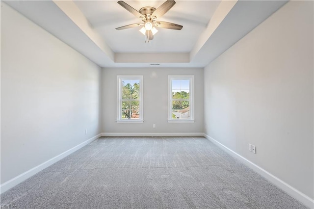 unfurnished room featuring ceiling fan, carpet flooring, and a tray ceiling