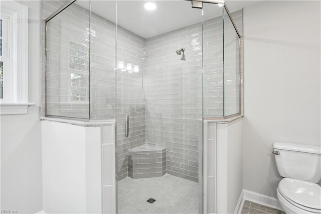 bathroom featuring toilet and a shower with shower door