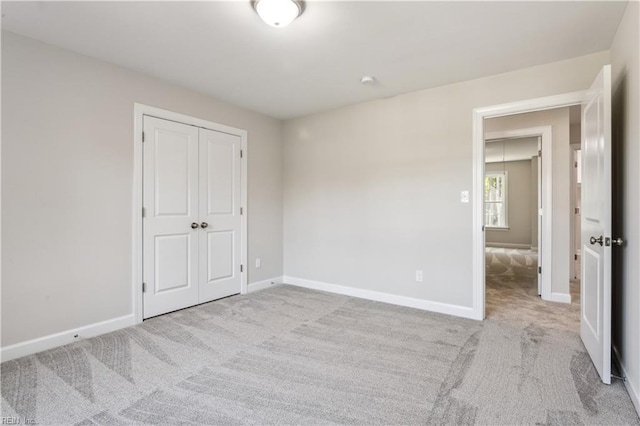 unfurnished bedroom featuring light colored carpet and a closet