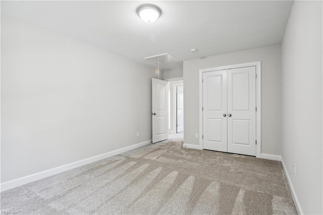 unfurnished bedroom featuring light colored carpet and a closet