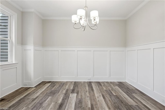 unfurnished dining area with ornamental molding, hardwood / wood-style floors, and an inviting chandelier