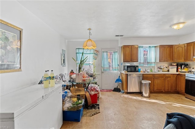 kitchen with appliances with stainless steel finishes, sink, and decorative light fixtures