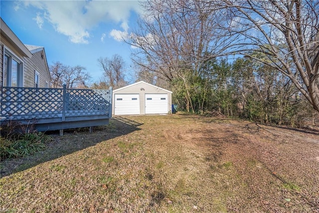 view of yard with a garage, an outdoor structure, and a deck