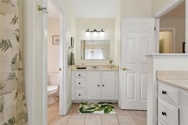 bathroom featuring vanity, tile patterned floors, and toilet