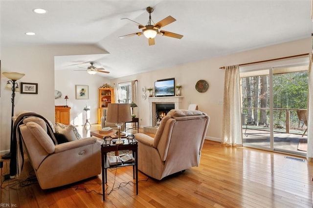 living room featuring vaulted ceiling, ceiling fan, and light wood-type flooring