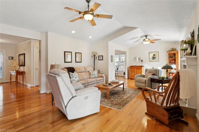 living room with lofted ceiling, light hardwood / wood-style flooring, ornamental molding, and ceiling fan