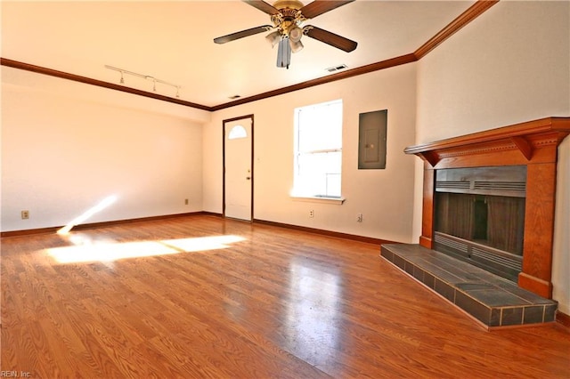 unfurnished living room featuring wood-type flooring, ornamental molding, electric panel, and a fireplace