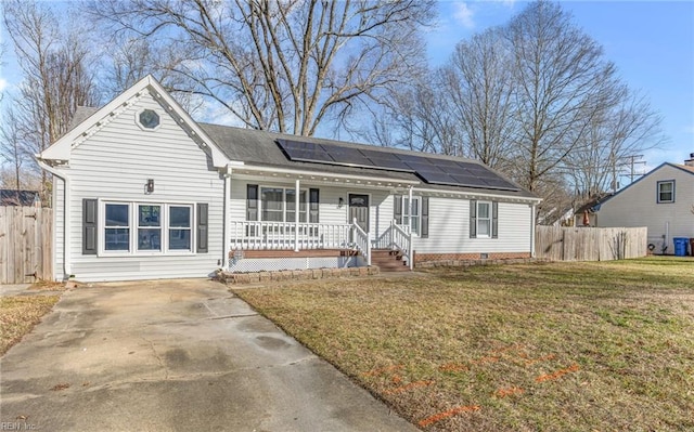 ranch-style house featuring a porch, a front lawn, and solar panels