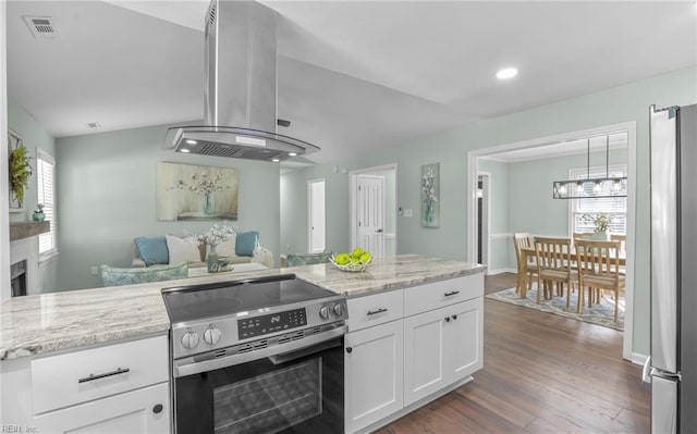 kitchen featuring white cabinetry, light stone counters, island range hood, and stainless steel appliances