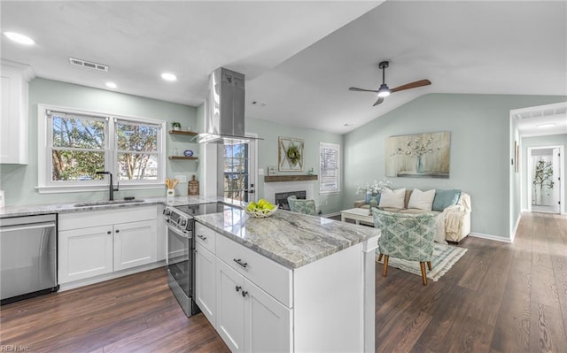 kitchen with sink, white cabinets, island exhaust hood, light stone counters, and stainless steel appliances