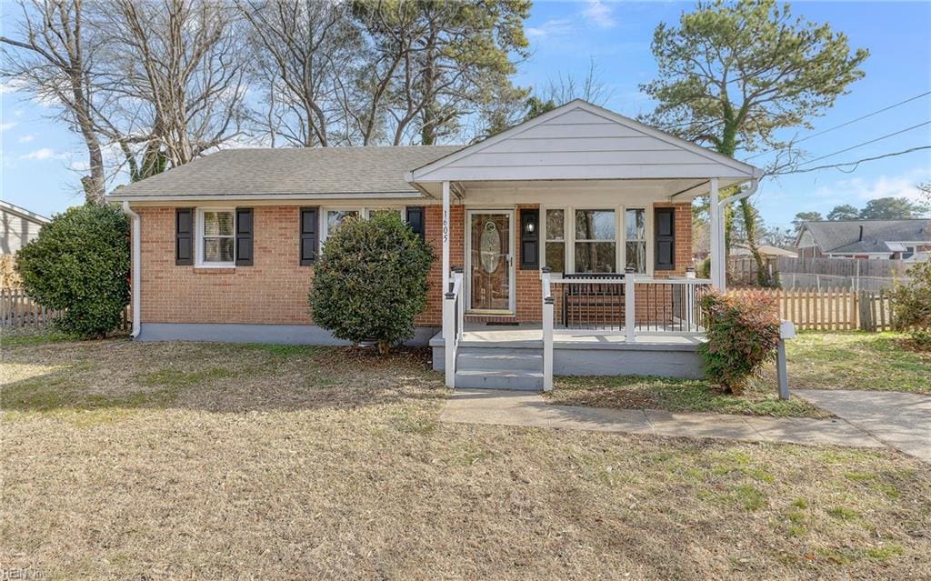 bungalow with covered porch and a front lawn