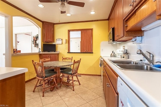 kitchen featuring sink, crown molding, light tile patterned floors, dishwasher, and ceiling fan