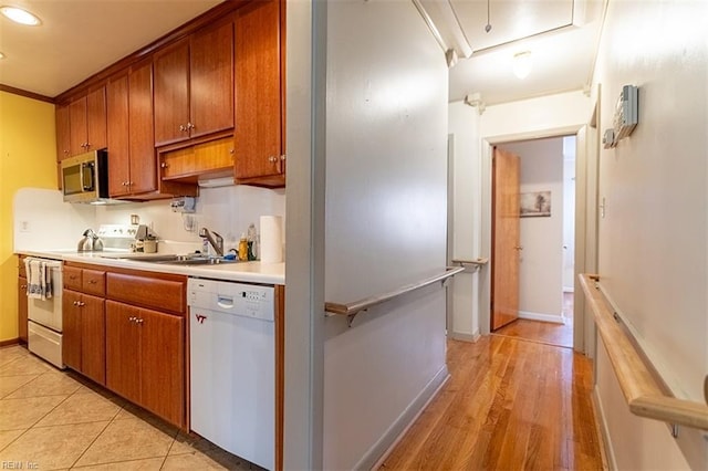 kitchen featuring sink, white appliances, and light tile patterned floors