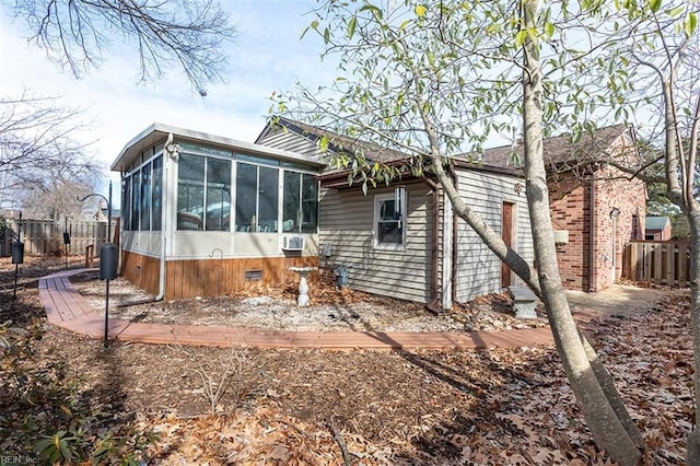 rear view of house featuring a sunroom