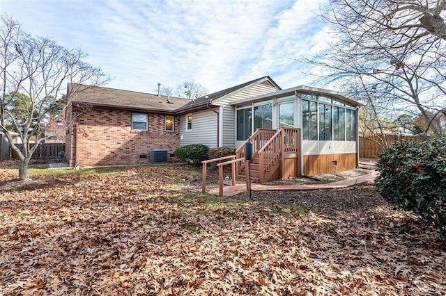 rear view of property featuring a sunroom and central air condition unit