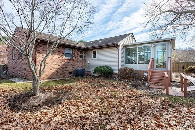 rear view of property with a sunroom and central air condition unit