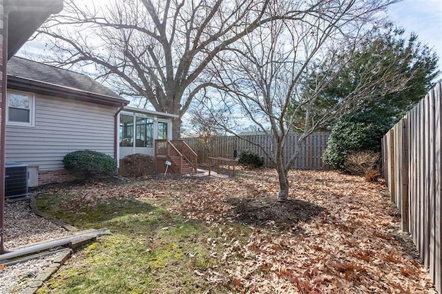 view of yard featuring central AC and a sunroom