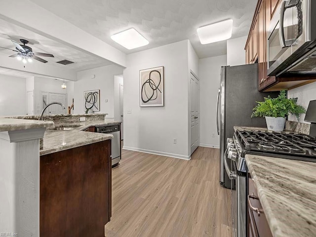 kitchen with sink, ceiling fan, stainless steel appliances, light hardwood / wood-style floors, and light stone countertops