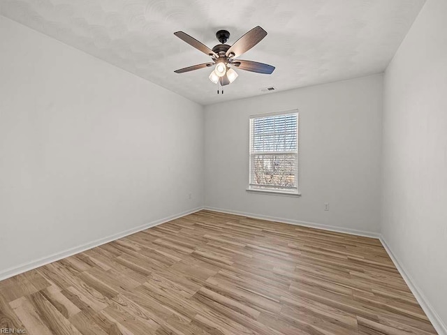 empty room with ceiling fan and light hardwood / wood-style floors