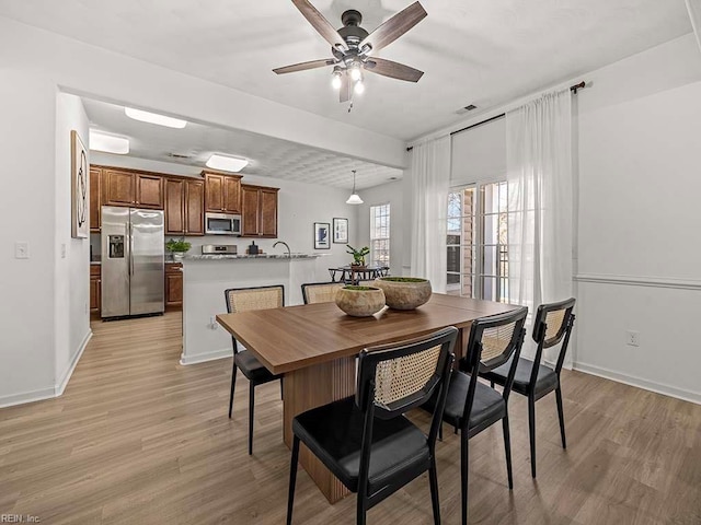 dining space with ceiling fan and light hardwood / wood-style floors