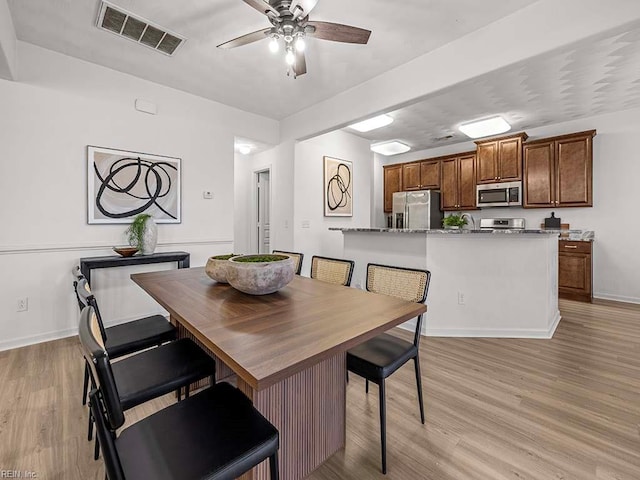 dining area featuring ceiling fan and light hardwood / wood-style flooring