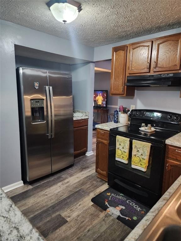 kitchen with dark hardwood / wood-style floors, stainless steel fridge, black range with electric cooktop, and a textured ceiling