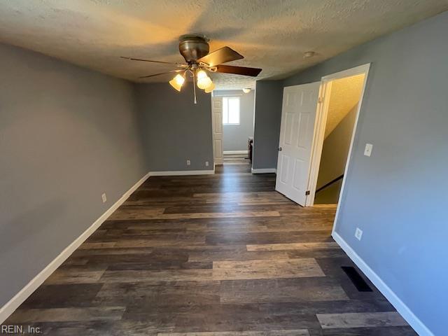 spare room featuring ceiling fan, baseboards, a textured ceiling, and wood finished floors