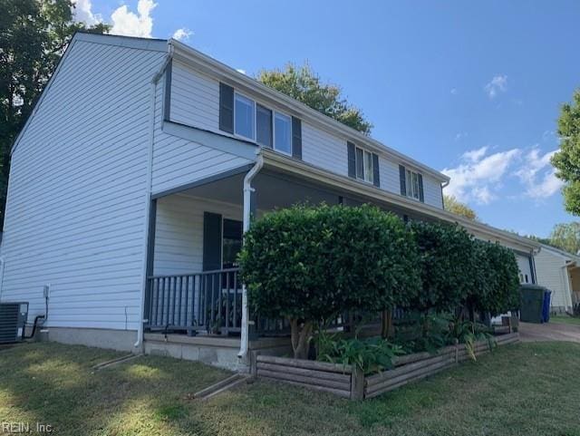 view of property exterior featuring cooling unit, covered porch, and a lawn