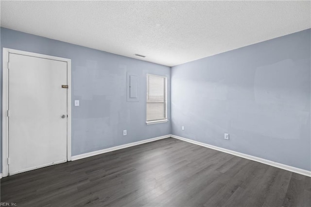 unfurnished room with dark hardwood / wood-style flooring and a textured ceiling