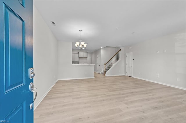 interior space with an inviting chandelier and light hardwood / wood-style floors